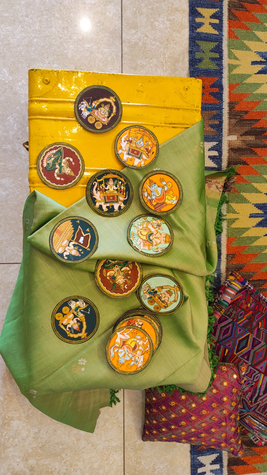 Hand-painted circular Mysore Ganjifa cards arranged on green silk